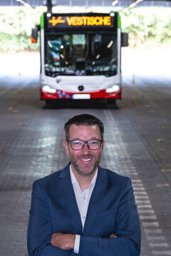 Holger Pietsch, Centerleiter Personal, steht in der Wagenhalle vor einem Bus.
